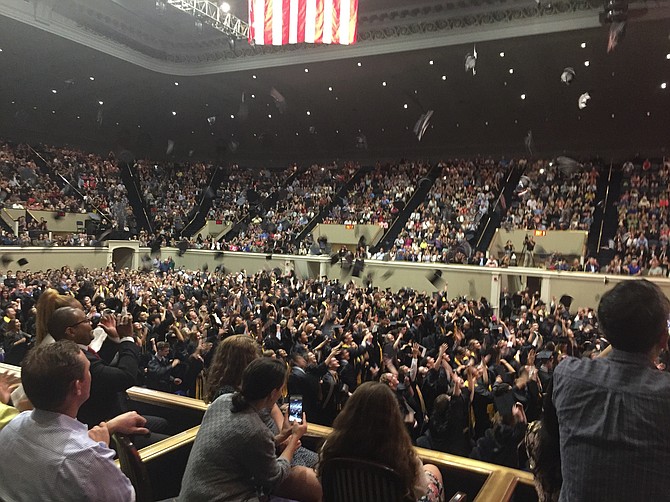 Graduates throw their caps in the air in celebration.