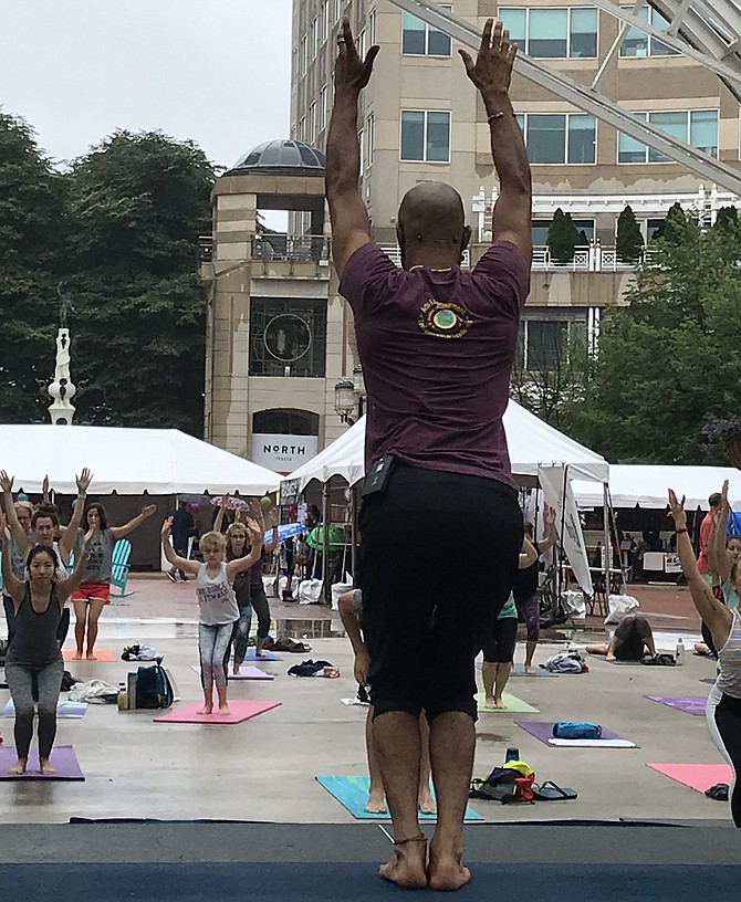 A yoga instructor teaches a free class as one of the activities held throughout the day at Love Your Body Yoga Festival, Reston Town Center, Sunday, June 9.