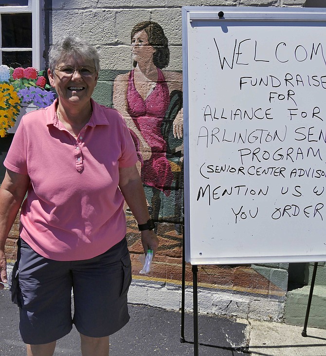 Honora Dent hands out tickets at Rocklands Barbecue & Grilling Company on Washington Boulevard June 4 at the Alliance for Arlington Senior Programs fundraiser.