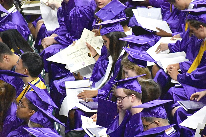 Graduates inspect their diplomas.