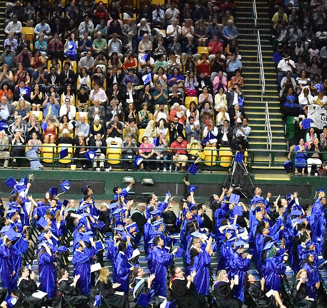 Students throw their caps in the air after graduating.
