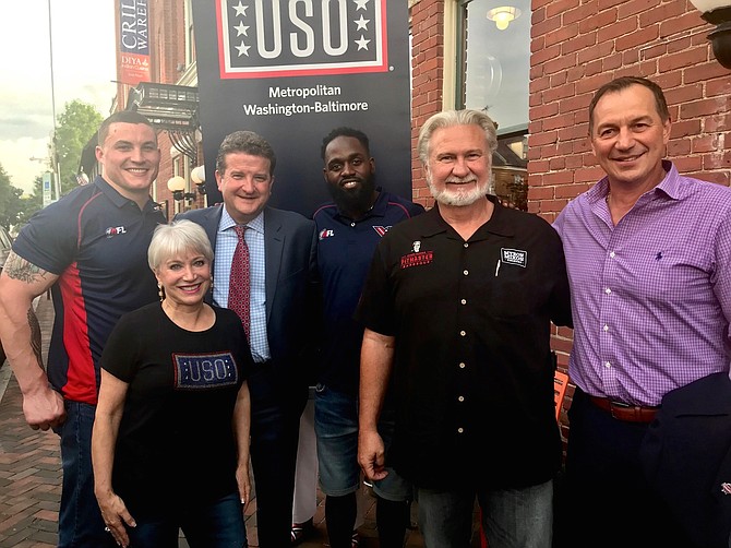 Former Washington Capitals player Peter Bondra, right, stands outside Myron Mixon’s Pitmaster BBQ Restaurant for the June 6 Red, White and BBQ fundraiser in support of USO Metropolitan Washington-Baltimore. Joining Bondra are: Washington Valor player Jimmy Gordon, USO President and CEO Elaine Rogers, voice of the Washington Wizards Dave Johnson, Washington Valor player Josh Reese and celebrity chef Myron Mixon.