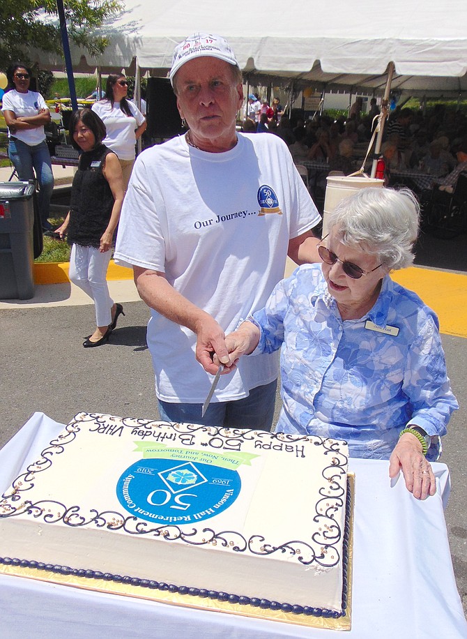 Thirty-year Vinson Hall resident Jane Peak and 30-year employee Fred Johnson cut the cake during the Vinson Hall 50th Anniversary Party on Saturday, June 22, 2019, in McLean.