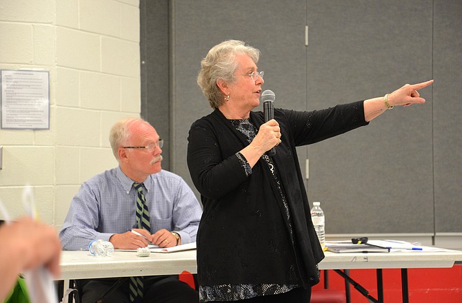 Fairfax County School Board member Jane Strauss takes questions from audience members who lined up to ask them and make comments at a standing-room-only, town hall-style meeting on topics like school boundaries and school overcrowding. Great Falls Citizens Association president Bill Canis keeps an eye on the proceedings.