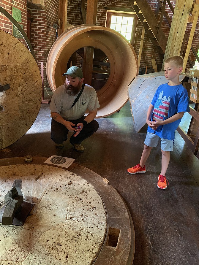 Issac Siren, 7, of Oakton, learns about the milling process by examining a disassembled grinding station.