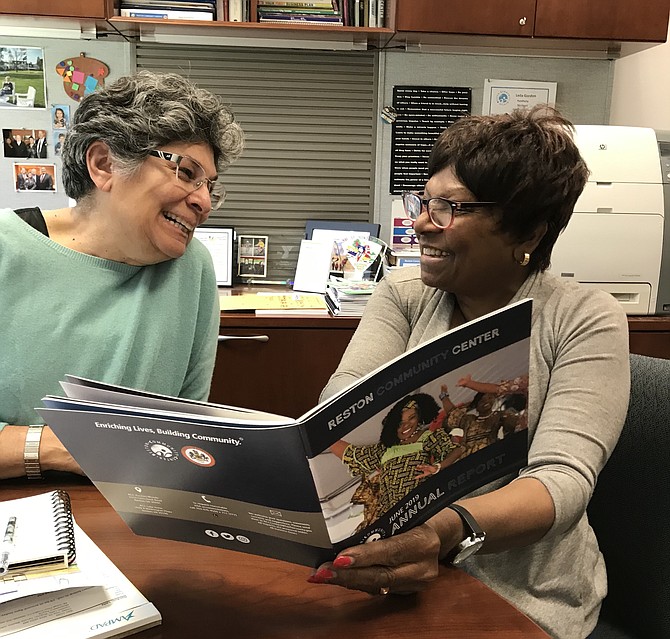 Reston Community Center Executive Director Leila Gordon and Chair of the Board of Governors Beverly Cosham review the June 2019 Annual Report.