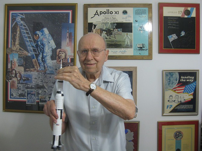 Great Falls resident Richard Cogan holds a model of the Saturn V rocket, which sent Apollo 11 on its way to the moon.