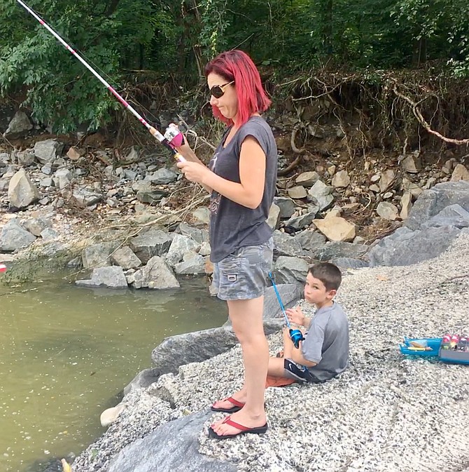 Lucas Yarushuk fishes with his mother on Four Mile Run. He used hot dogs as bait and said he had already caught a nice-sized eel and a fairly large fish. His mother said she would use the eel for Unani sushi.