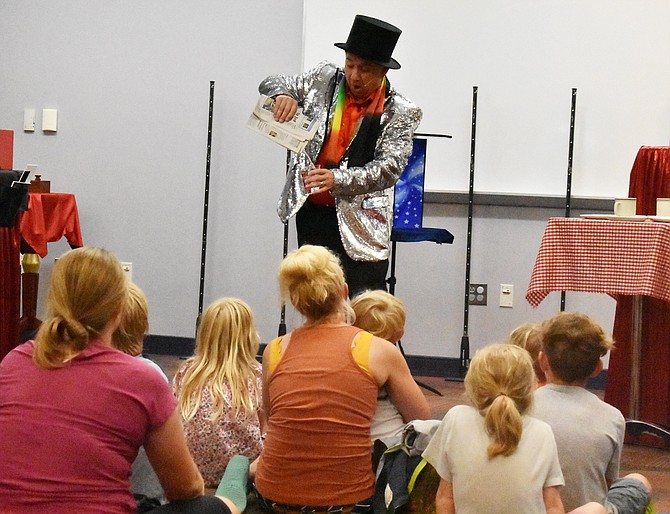 Magician Steve Somers pours water from a newspaper.