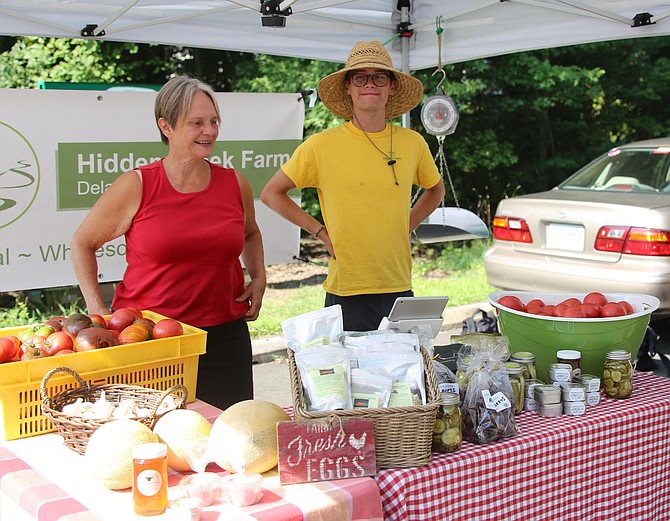 Owner of Hidden Creek Farm, Angela Young, and her intern Matt Zaremba, are greeting everyone who enters the market.