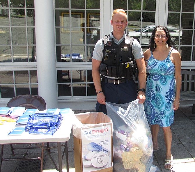 Alexandria Police officer Dylan Ignacio and volunteer Mary Luceri collect prescriptions at First Baptist Church on King Street.