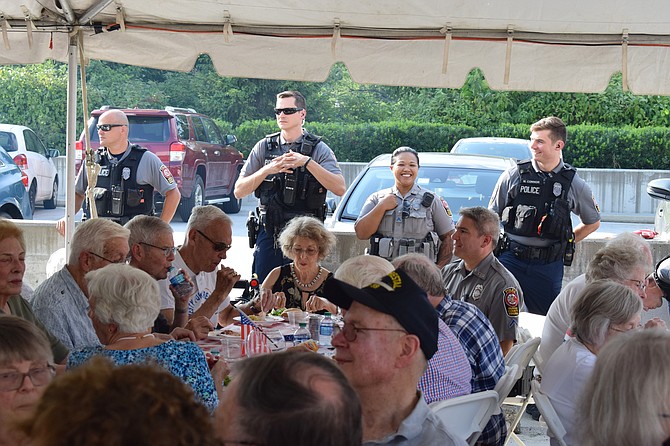 Fairfax County Police officers look on during remarks made at National Night Out. Vinson Hall hosts National Night Out as a way to say thanks to the many first responders who support the community every day.