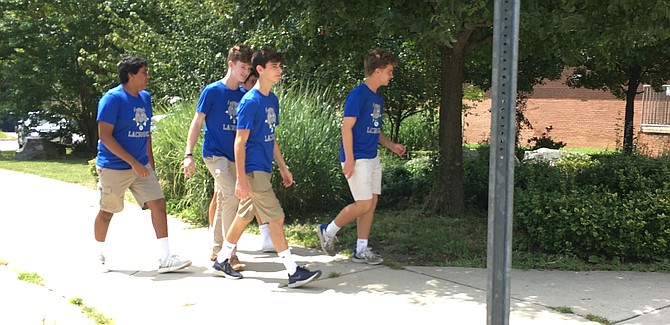 Members of Winston Churchill High School lacrosse team enter the school for the memorial service for Jake Cassell, a rising junior and the person behind the Churchill Bulldog mascot at the school. Jake died from injuries sustained in a biking accident.
