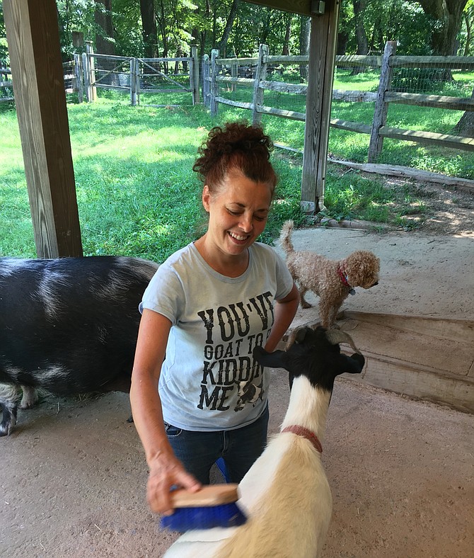 Dr. Susan Rich operates Dream Catcher Meadows in Potomac, providing supportive programs for individuals with Fetal Alcohol Spectrum Disorders and other neurodevelopmental disorders. Here she grooms one of her very tame goats that help children feel comfortable on the farm.