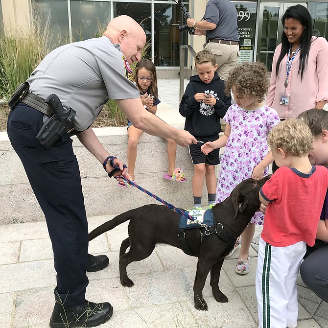 Children say hello to First Responder K9 Service Dog in Training Indy, and her handler Fairfax County Chief of Police Colonel Edwin C. Roessler Jr., during the department’s Meet & Greet the Service Dogs.