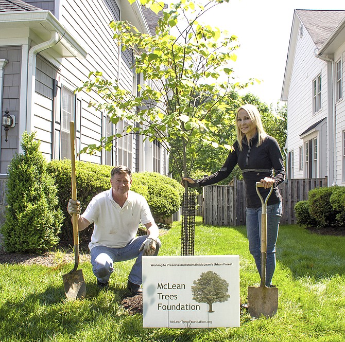 Heather Young and Bill Buckley with their newly planted redbud tree.