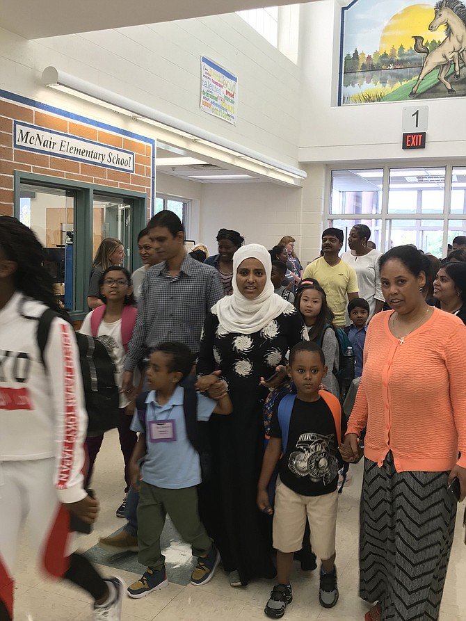 Hand in hand, family members and friends make their way to classrooms on the first day of the school year 2019-2020 at McNair Elementary in Herndon.