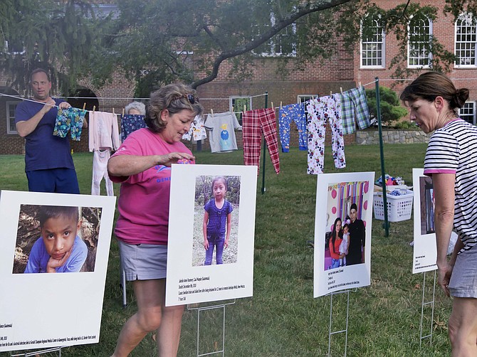 Rev. Kathy Dwyer installs the photo poster of Jakelin Amez Rosmery from Guatemala who died Dec. 8 where she was detained at Antelope Wells, New Mexico. With her are Denise Sisson, coordinator of the project (right), and Jeff Hogarth (left).