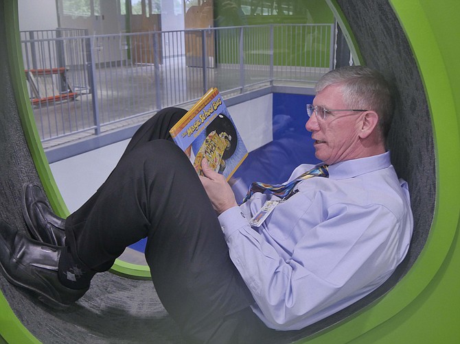 Jeff Chambers, director of Design and Construction for Arlington County Public Schools, demonstrates a reading nook in the second floor library.