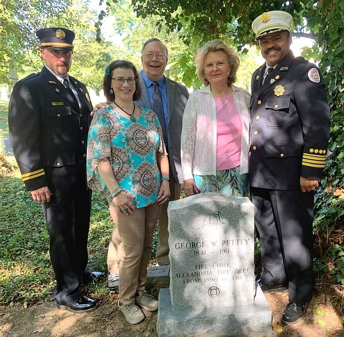 Acting Fire Chief Corey Smedley, right, poses for a photo with Captain Jason Kuehler, left, and Friendship Fire Engine Veterans Association Trustees Catherine Weinraub, Joe Shumard and Marion Moon at the newly unveiled gravestone of Fire Chief George Pettey Aug. 30 at Bethel Cemetery. Pettey died in the line of duty in 1911 and buried in an unmarked grave.