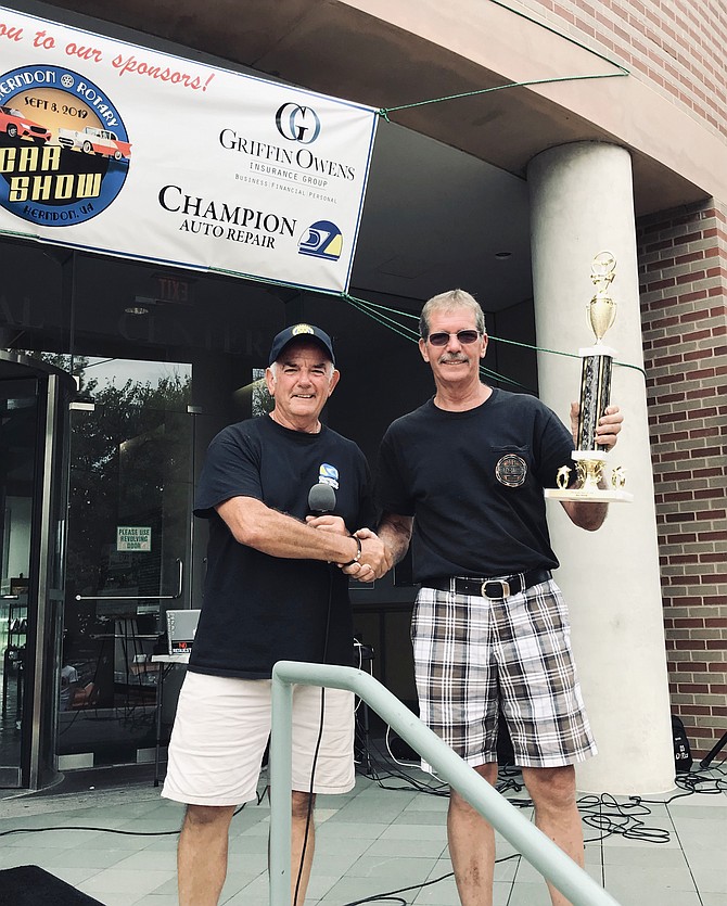 Rudy Tassara, President-Elect of Herndon Rotary Club and event organizer, presents Mike Rollison with the Best Overall award for his iconic 1969 Chevrolet Camaro at the 2019 Herndon Rotary Car Show.