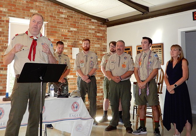 Scoutmaster Emeritus Kevin Gaughan speaks, while the Whalens, (from left) Ryan, Matt, Sean, Kevin, Connor and Patti, listen.