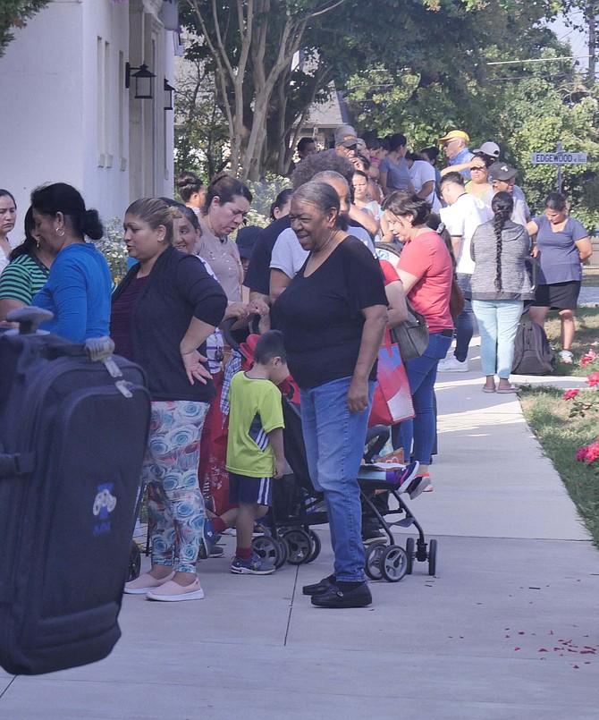 Immigrants line up early outside Our Lady Queen of Peace for the food pantry and other ministries to assist immigrant families.
