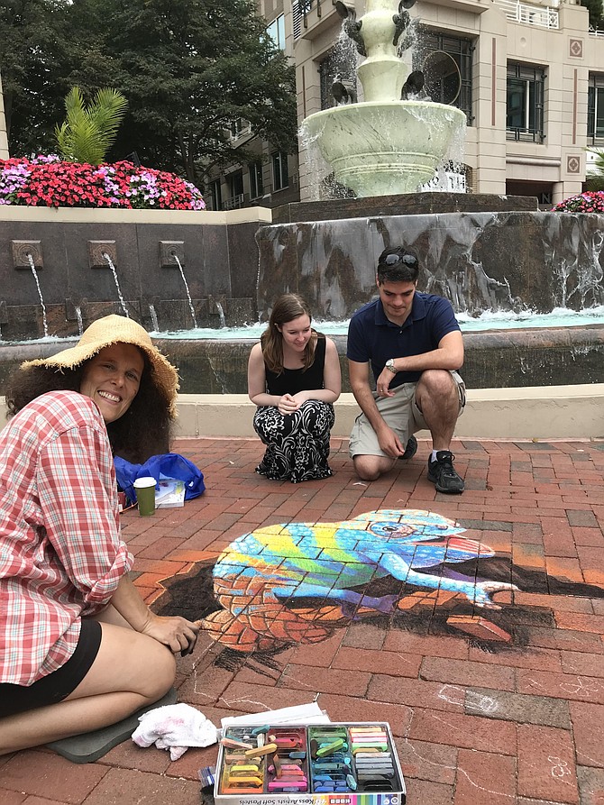 Professional artist Penny Hauffe begins her work that later would win 1st Place Professional as Beth Semel and Max Duhe of Alexandria admire her progress during Chalk Fest at RTC 2019.
