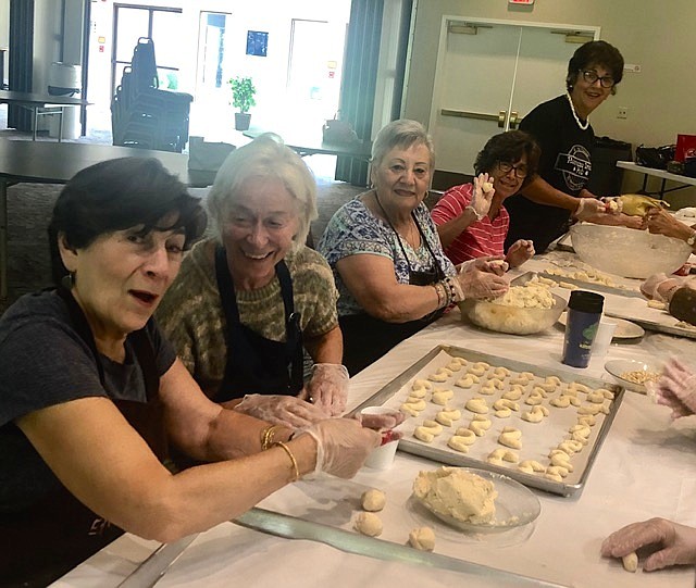 Church volunteers last year preparing bird’s nests, ghrabee cookies, S-shaped.