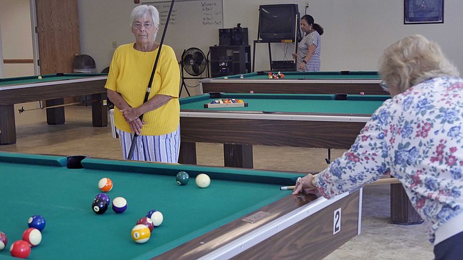 Diane Hill and Betty Roadcap face off in the 80s age division of 8-ball pool.