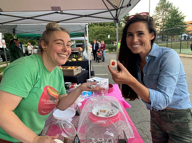 Shelbie Koch holds a specialty cookie with Politics to Pastries’ Amy Duval at the second annual Taste of Old Town North Sept. 19 at Montgomery Park.