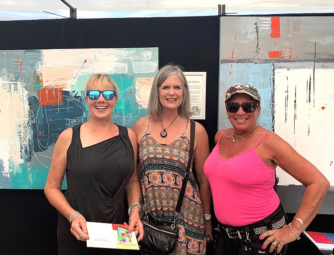 Artist Carol Ryan of Chicago, center, poses for a photo with fellow artists in front of her acrylic artwork during the King Street Art Festival Sept. 22.