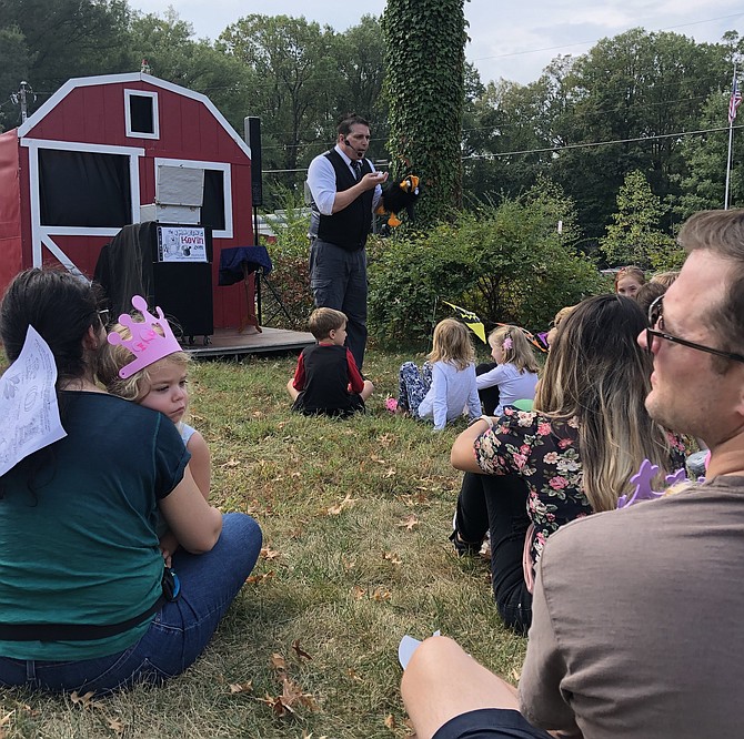 Families watch as the Amazing Kevin performs some magic with the help of his assistant bird named CC.