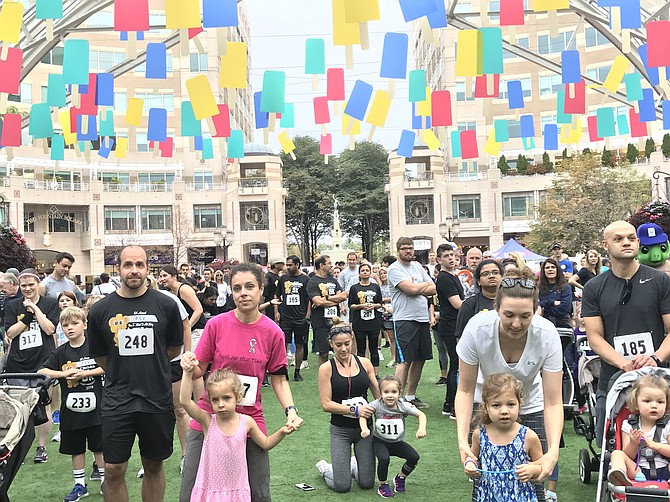 Parents help their children during warm-ups before the start of the 5th annual 5K & Family Health Fair: Race To Make It All Better at Reston Town Center to benefit the nonprofit medical group practice, Pediatric Specialists of Virginia (PSV) located in Fairfax.