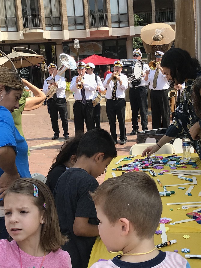 Children create art as the New Line Brass band goes New Orleans-style with a processional around the festival grounds, following the Welcome Ceremony and Naturalization Ceremony during the 2019 Reston Multicultural Festival.