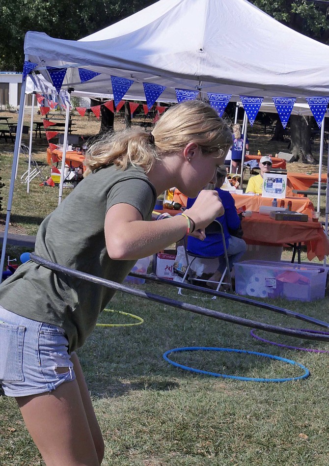 Elizabeth Schneider concentrates on keeping her hoop circling in the hula-hoop contest at BBQ, Boots and Bingo, Saturday, Sept. 28 at the Columbus Club of Arlington.