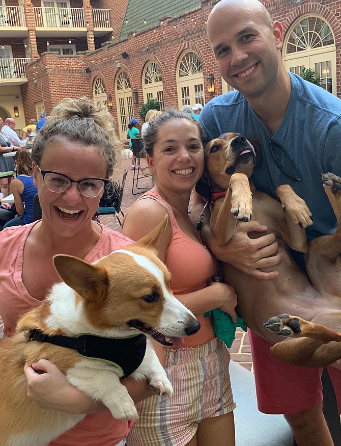 Nicole Jacques, left, holds Theo, while Jamie Tannura and Luke Thomas cradle Cypress, at the Barks and Brews fundraiser for the Alexandria Police Foundation Sept. 12 at The Alexandrian Hotel.