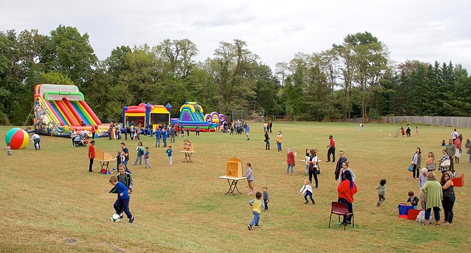 Children spread out over the Potomac Community Center fields enjoying inflatables and games.