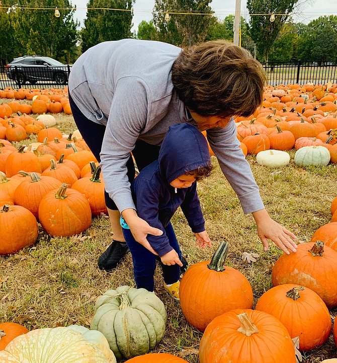Maria Legonia helps Lee Shuffler select a pumpkin Oct. 8 at the Immanuel-Church-on-the-Hill Pumpkin Patch. The pumpkin patch is open seven days a week through Oct. 31 and sales benefit local charities.
