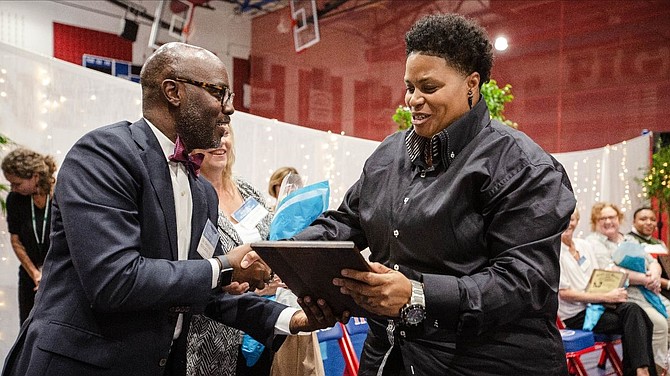 ACPS Superintendent Gregory C. Hutchings Jr. presents a plaque to Tanya Galloway-White at the Oct. 3 T.C. Williams Athletic Hall of Fame Induction Ceremony.