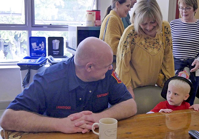 Ryan Pavelich sits at the firehouse kitchen table with Captain Lightfoot.