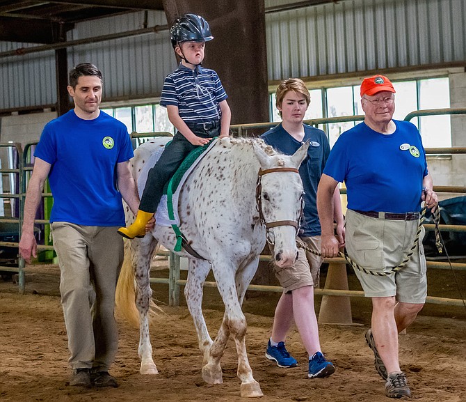 Happy enjoying a therapeutic riding lesson with his friend Carson.