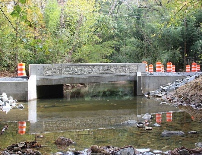 One-lane traffic is in place as crews finish the guardrail and other details.