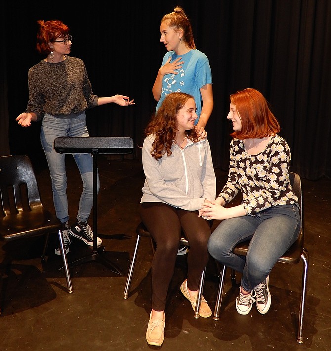 Rehearsing a scene from Woodson High’s “Letters to Sala” are (standing, from left) Rebecca Heimbrock (Ann) and Rachel Furr (Ann’s daughter) and (sitting, from left) Rebecca Sitrin (older Sala) and Anna Riley (Ann’s other daughter).