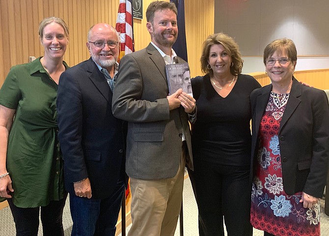 City of Alexandria Commonwealth’s Attorney Bryan Porter, center, holds a copy of his book “The Parable of the Knocker” at a book discussion Oct. 7 at the Alexandria campus of Northern Virginia Community College. With Porter are School Board vice chair Veronica Nolan, Porter’s father John Porter, City Council member Amy Jackson and Cathy David.