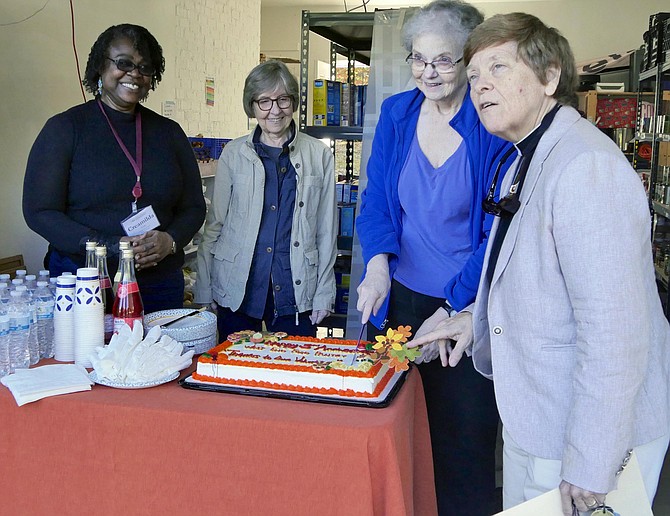 Cutting the birthday cake at West End Pantry, Monday, October 28. From left: Creamilda Yoda, parish administrator and first year seminary student, Louise Bennett, Kat Turner, Rev. Jo Belser, Church of the Resurrection.