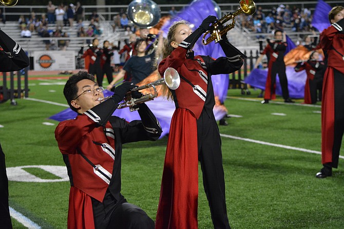 The James Madison High School Marching Ensemble performing at a Madison football game.