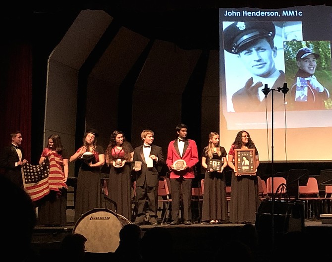 Pride of Herndon students displaying the historical artifacts from USS Herndon, including the first U.S. flag to fly over German-occupied territory on D-Day.