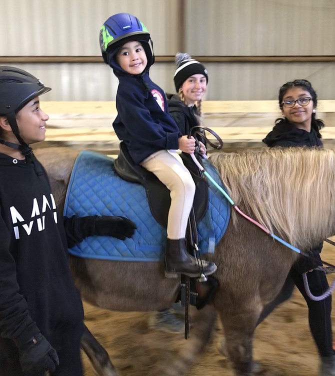 Rider Aaron Ho, 5, of Fairfax, Naomi Jacobs, 11, of Fairfax, Elena Brunori of Vienna, and Sagarika Kagicha, 13, of Fairfax at "Ride4SPIRIT," held Sat., Nov., 9, Frying Pan Farm Park Equestrian Center, Herndon.