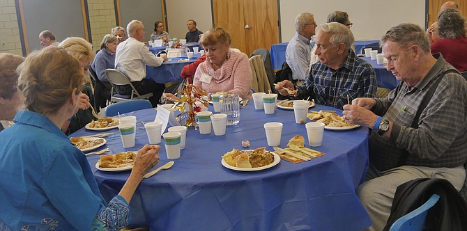 Lucky table 4 is the first to eat at the annual Thanksgiving lunch.